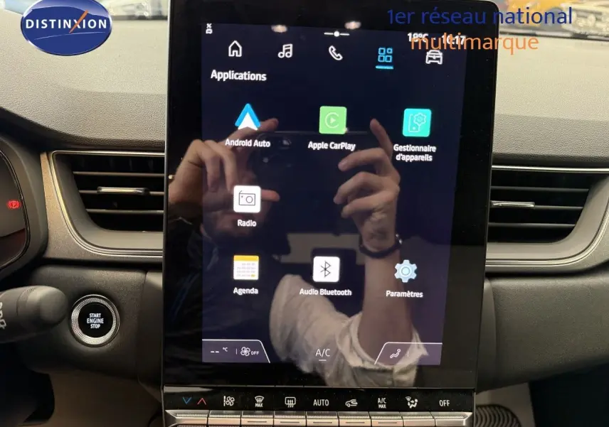 Écran tactile central du tableau de bord du Renault Captur 2025, avec commandes climatisation et démarrage moteur visibles.