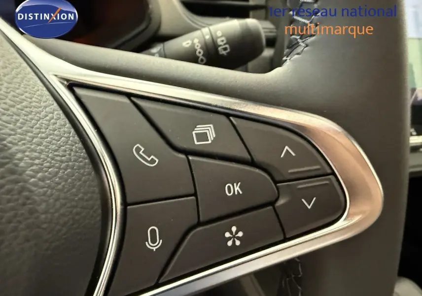 Gros plan sur les commandes multifonctions à droite du volant du Renault Captur gris Cassiopée, boutons noirs avec icônes blanches.