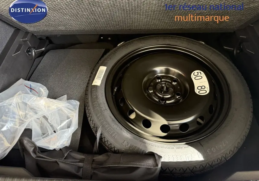 Gros plan sur la roue de secours noire dans le coffre d’un Renault Captur gris Cassiopée Métal 2025.