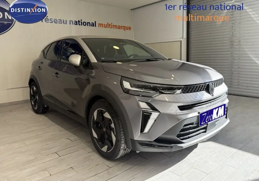 Renault Captur 2025 gris cassiopée métal avec toit gris, vu en 3/4 avant droit dans un showroom.