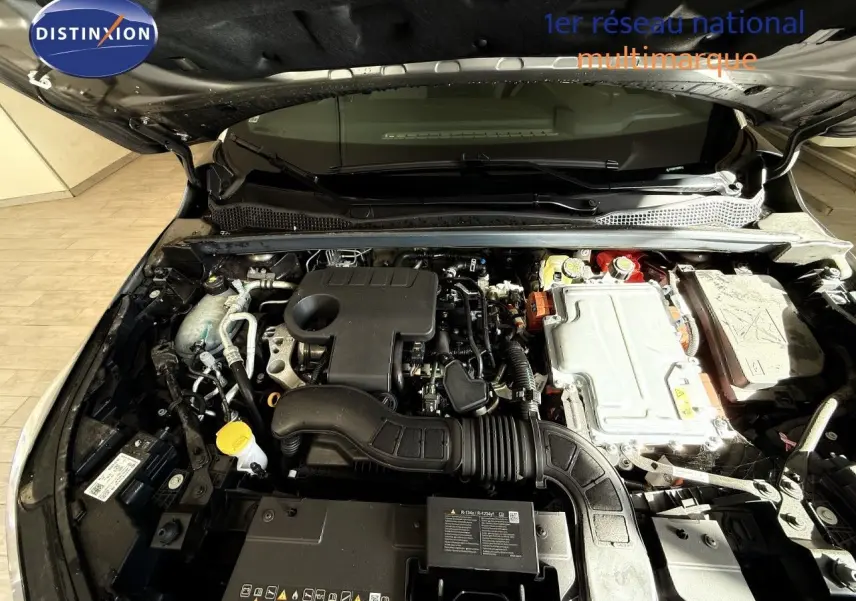 Moteur hybride Renault Captur 1.6 E-Tech 2025 vu de dessus, compartiment moteur ouvert, détails techniques visibles.