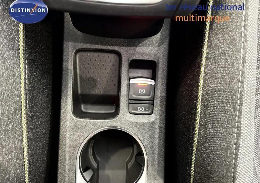 Vue rapprochée de la console centrale du Renault Captur gris cassiopée, avec bouton frein à main électronique et surpiqûres jaunes.