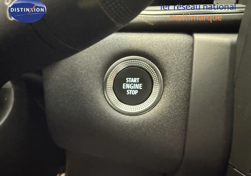Bouton start engine stop en gros plan sur le tableau de bord d'une Renault Captur gris cassiopée métal 2025.