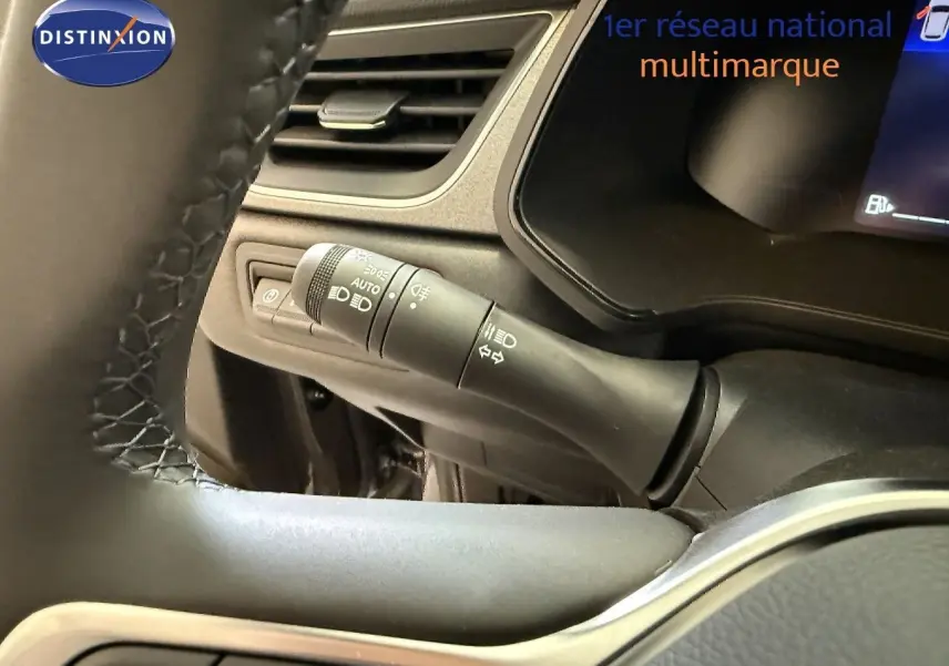 Détail du commodo d'éclairage à gauche du volant dans l'habitacle du Renault Captur gris Cassiopée 2025.