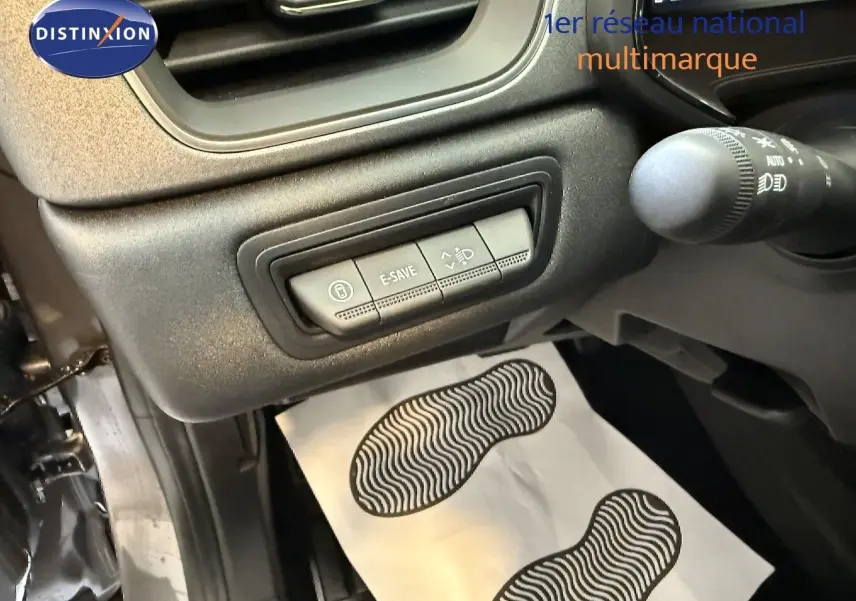 Vue rapprochée du tableau de bord côté gauche du Renault Captur gris cassiopée, montrant les commandes E-SAVE et réglage des phares.