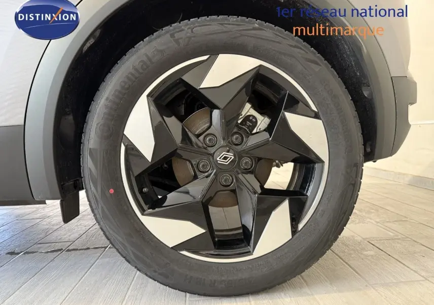 Gros plan sur la roue avant droite du Renault Captur gris Cassiopée avec jante noire et argentée au design géométrique.