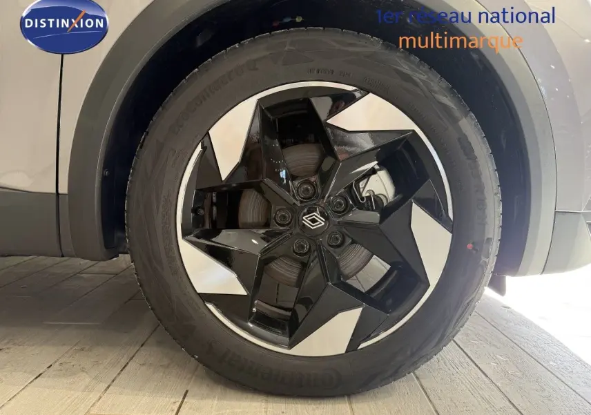 Gros plan sur la roue avant droite du Renault Captur gris Cassiopée avec jante noire et argentée au design géométrique.