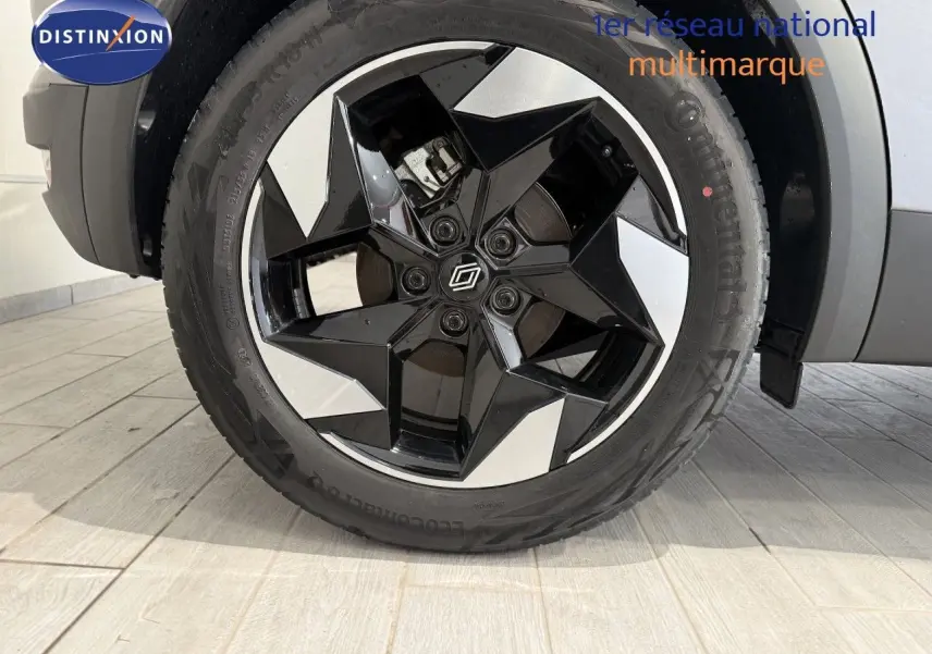 Gros plan sur la roue avant droite du Renault Captur gris Cassiopée, jante alliage noire et argentée au design géométrique.