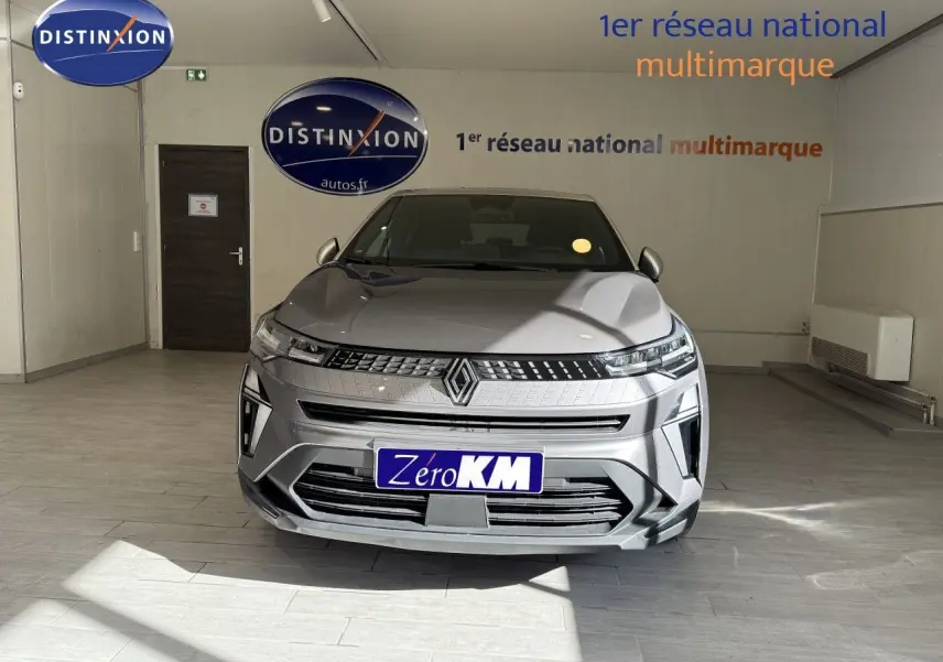Vue frontale d'un Renault Captur gris Cassiopée métal avec toit gris, dans un showroom lumineux.