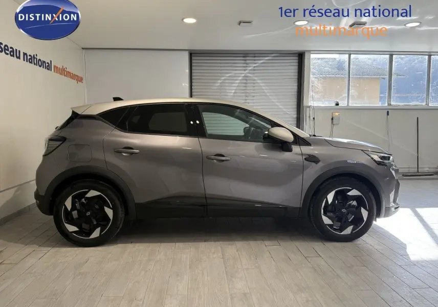 Profil droit du Renault Captur 2025 gris Cassiopée métal avec toit gris, jantes noires bicolores et vitres teintées.