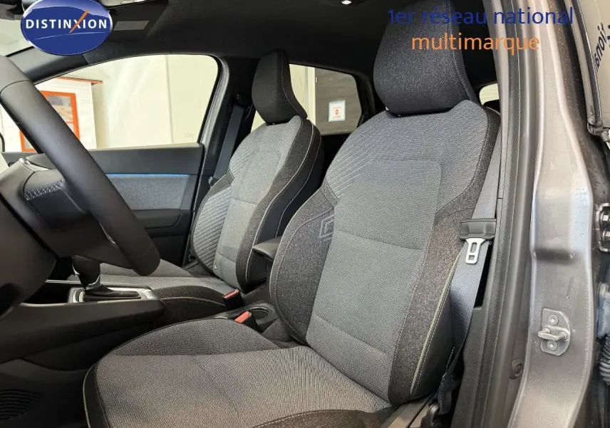 Vue intérieure côté droit du Renault Captur 2025 gris cassiopée, mettant en valeur les sièges tissu gris et noir.