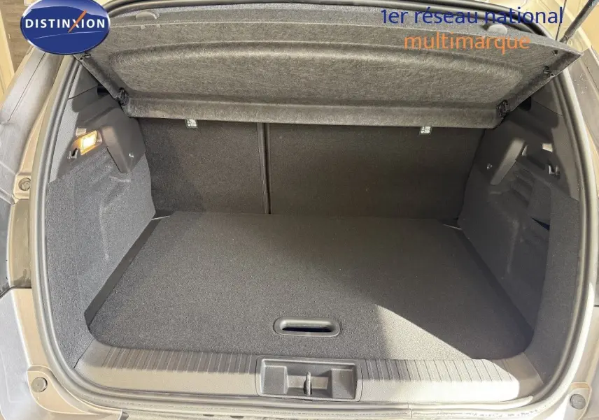 Coffre ouvert vu de l'arrière du Renault Captur gris Cassiopée métal avec intérieur de coffre noir et cache-bagages relevé.