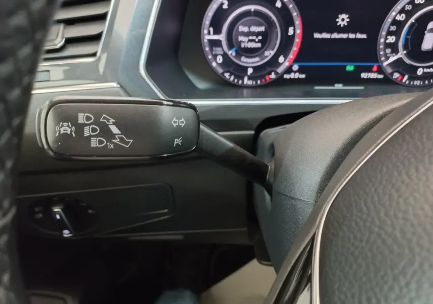 Gros plan sur la commande de clignotants et tableau de bord numérique du Volkswagen Tiguan Allspace 2018.