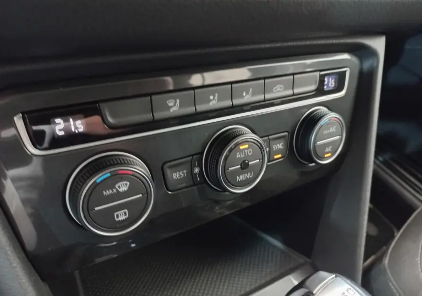 Gros plan sur la console centrale du Volkswagen Tiguan Allspace 2018, commandes de climatisation digitales et boutons noirs.