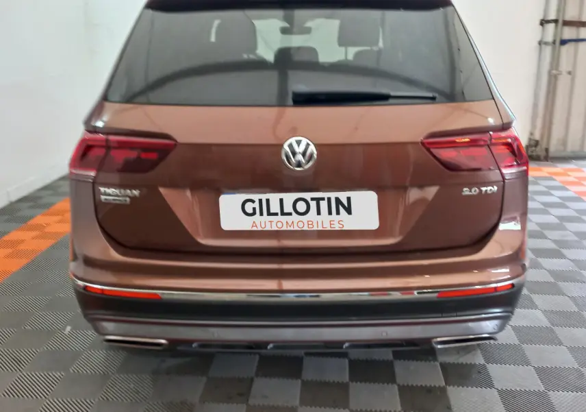 Vue arrière d'un Volkswagen Tiguan Allspace marron 2.0 TDI avec feux LED et double sortie d'échappement chromée.