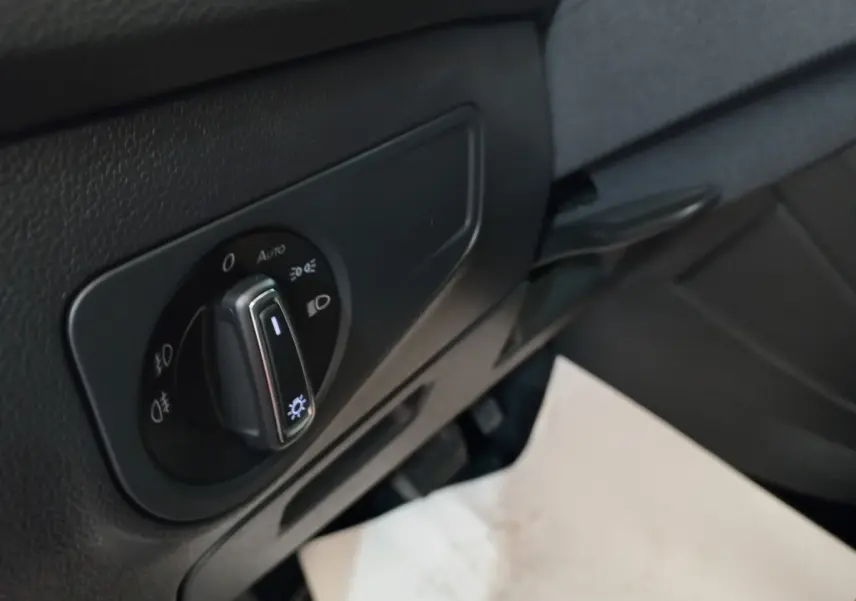 Gros plan sur le sélecteur d'éclairage noir du tableau de bord côté gauche du Volkswagen Tiguan Allspace marron 2018.