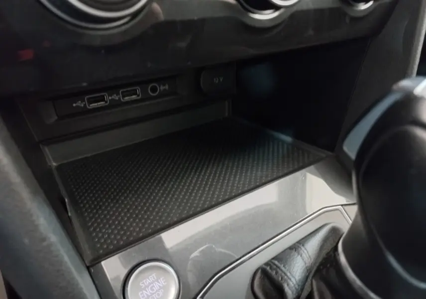 Gros plan sur la console centrale du Volkswagen Tiguan Allspace marron, montrant bouton démarrage et prises USB