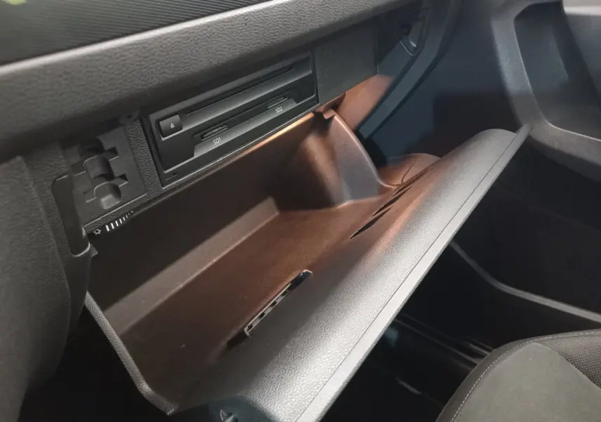 Gros plan sur la boîte à gants ouverte du Volkswagen Tiguan Allspace 2018, intérieur noir avec lecteur SD visible.