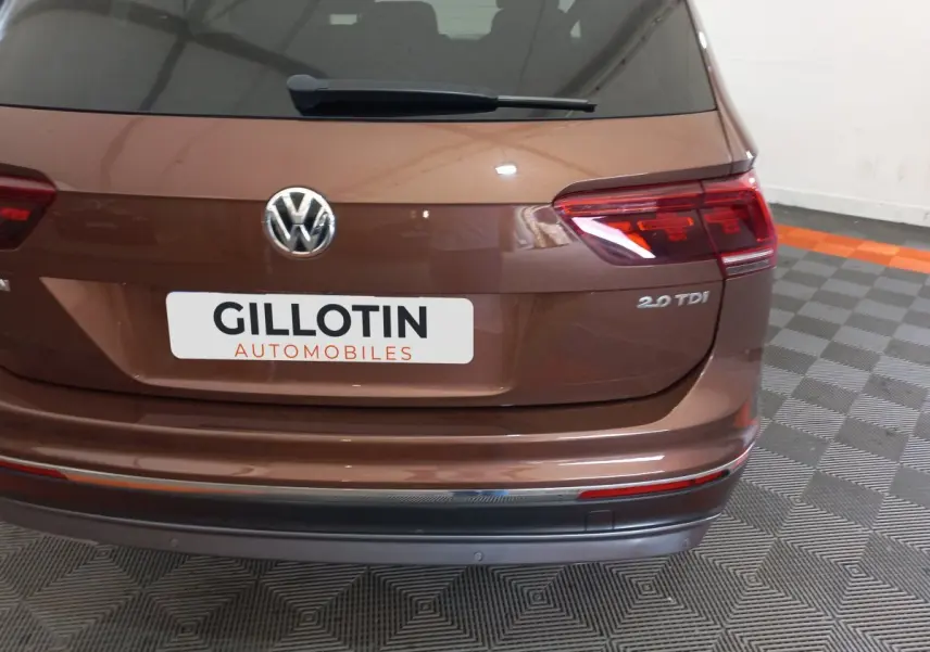 Vue arrière d'un Volkswagen Tiguan Allspace marron 2.0 TDI avec logo VW et feux arrière LED visibles