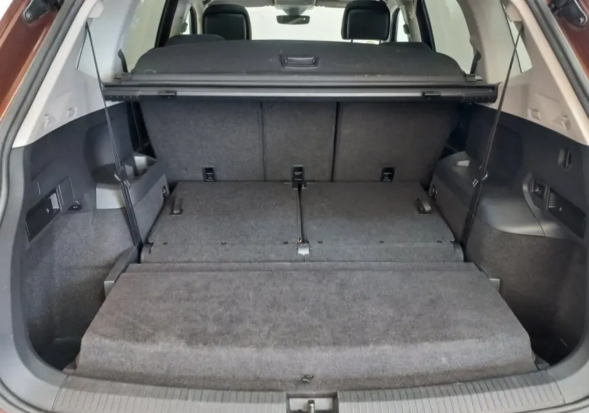 Coffre ouvert du Volkswagen Tiguan Allspace 2018, montrant la 3ème rangée rabattue et plancher plat intérieur gris.