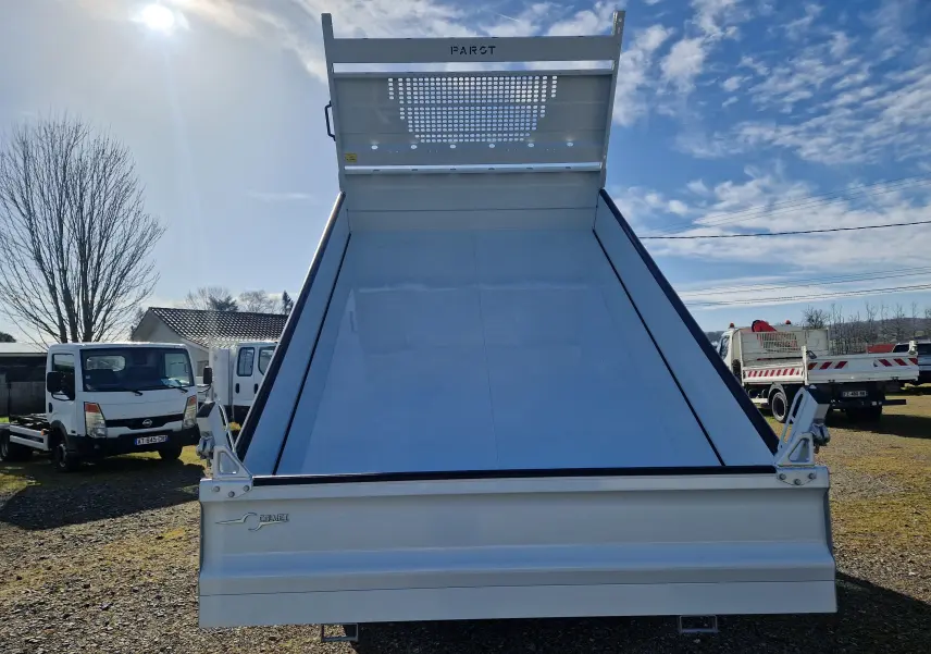 Vue arrière d’une benne blanche Calvet relevée sur un Iveco Daily Châssis Cabine 2026, sous un ciel bleu.