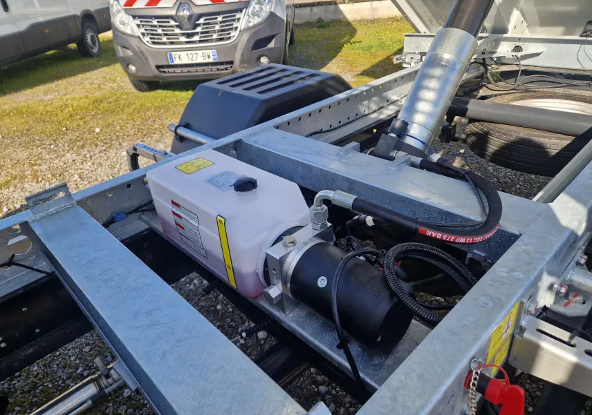 Gros plan sur le châssis métallique gris du Daily Iveco blanc, montrant le réservoir et les composants hydrauliques.