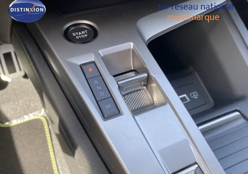 Gros plan sur la console centrale de la Peugeot 308 hybride 2026, montrant le bouton start/stop et la commande de boîte auto.