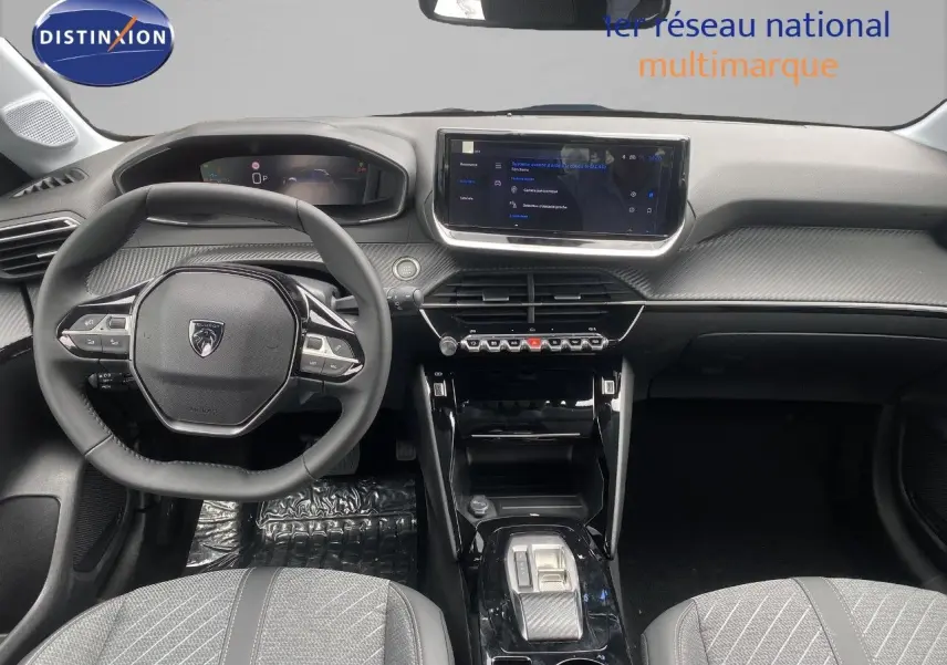 Vue intérieure avant du tableau de bord de la Peugeot 208 Hybrid 110ch avec volant compact et écran tactile central.