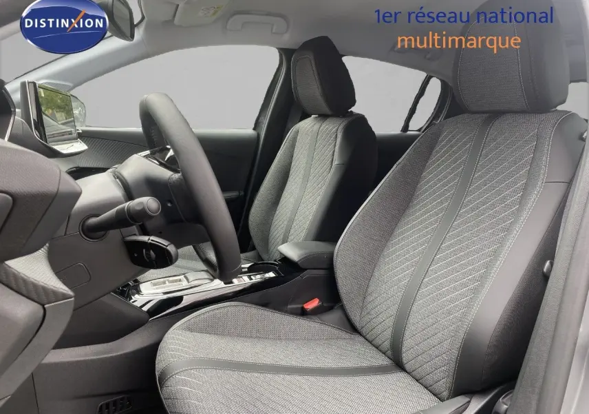Vue intérieure côté conducteur de la Peugeot 208 Hybrid 110ch Allure avec sièges tissu gris et volant cuir multifonction.