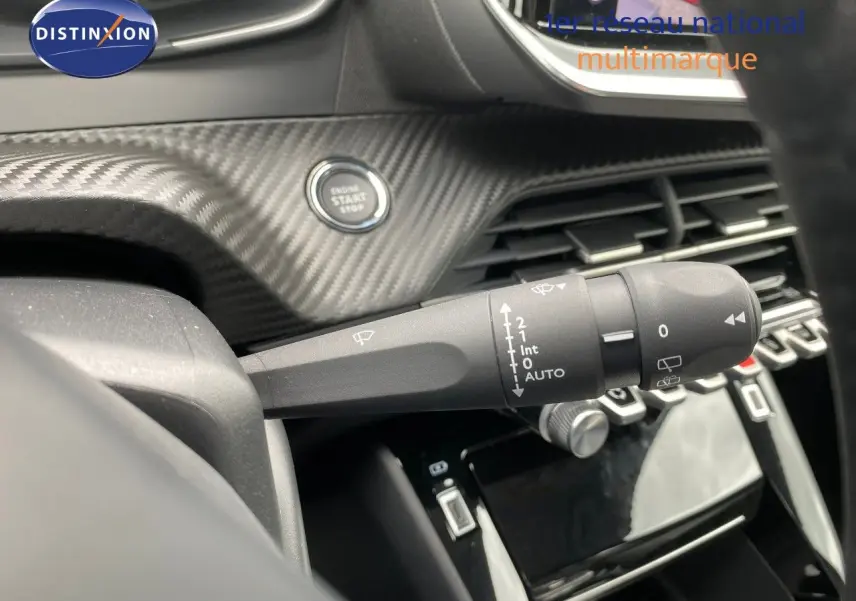 Gros plan sur la commande d’essuie-glace à gauche du volant dans l’habitacle gris et noir d’une Peugeot 208 Hybrid 110ch 2026.