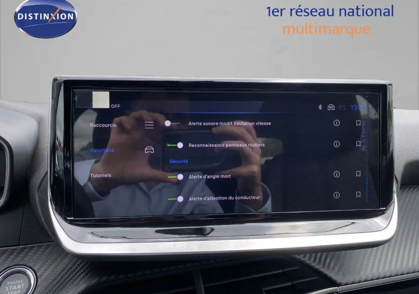 Écran tactile central du Peugeot 208 Hybrid gris sélénium, affichant les options d’alerte et sécurité.