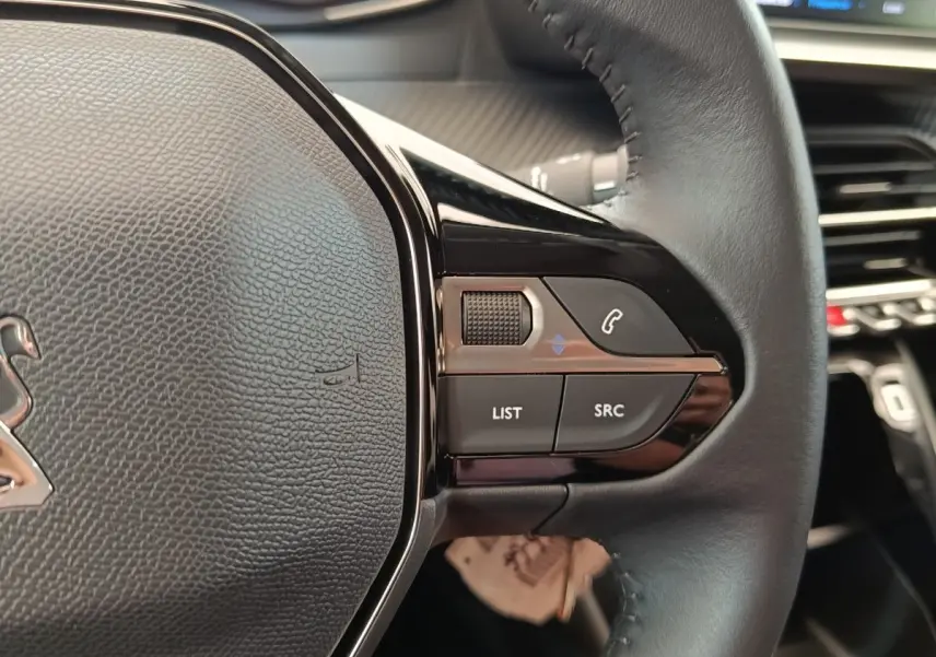 Gros plan sur les commandes multifonctions à droite du volant cuir noir du Peugeot 208 PureTech 75 S&S Style 2023.