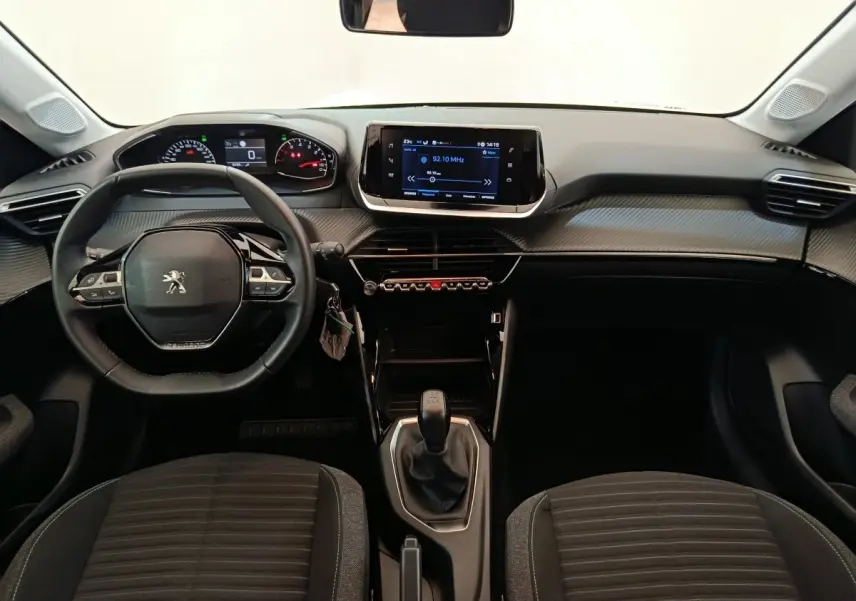 Vue intérieure frontale du tableau de bord et volant cuir noir de la Peugeot 208 PureTech 75 S&S Style 2023.