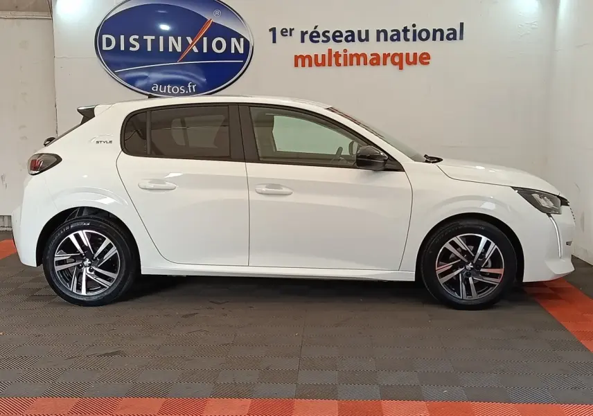 Profil droit de la Peugeot 208 PureTech 75 S&S Style blanche, avec jantes alliage et rétroviseurs noirs, en intérieur showroom.