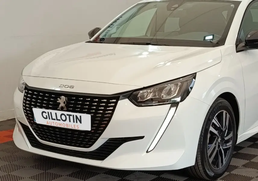 Peugeot 208 PureTech 75 S&S Style blanche vue 3/4 avant droit, avec calandre noire et feux LED distinctifs.