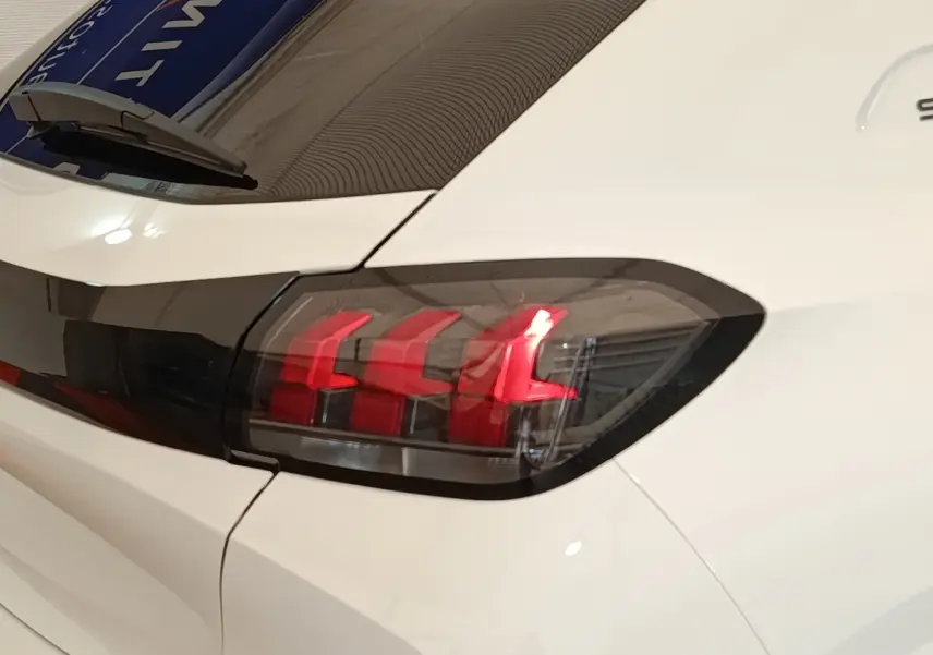 Feu arrière droit allumé d'une Peugeot 208 PureTech 75 S&S Style blanche vue en gros plan sur l'arrière.