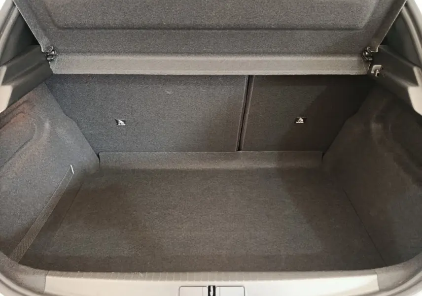 Coffre ouvert vu de face de la Peugeot 208 PureTech 75 S&S Style 2023, revêtement intérieur gris foncé.