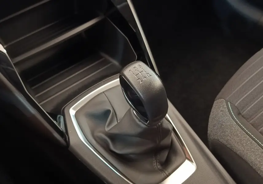 Gros plan sur le levier de vitesses manuel noir de la Peugeot 208 PureTech 75 S&S Style, intérieur gris.