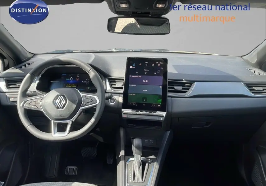 Vue frontale de l'intérieur du Renault Captur 2025, tableau de bord noir avec écran tactile vertical et volant multifonction.