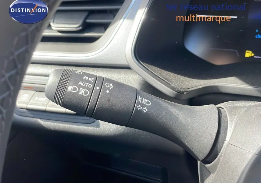 Gros plan sur la commande des phares et clignotants à gauche du volant dans l’habitacle du Renault Captur noir étoile métal.