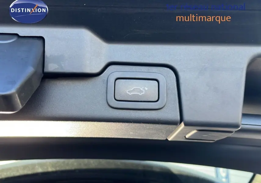 Bouton d'ouverture électrique du hayon sur un Range Rover Evoque blanc, vue en gros plan intérieur du coffre.