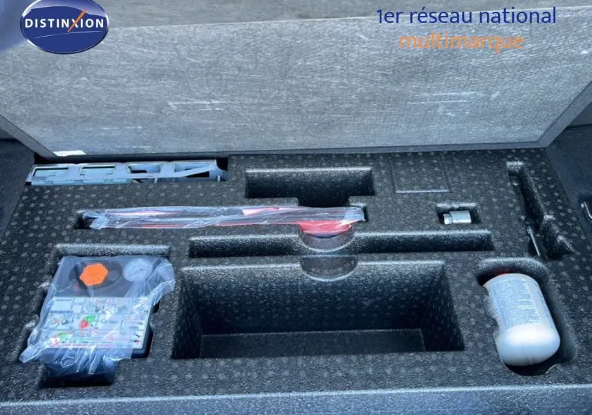 Compartiment de rangement dans le coffre d'un Range Rover Evoque blanc 2017, montrant les outils et accessoires d'origine.