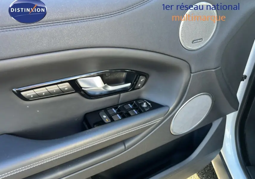 Gros plan sur la porte avant gauche blanche du Range Rover Evoque 2017, mettant en valeur les commandes et haut-parleurs intégrés.