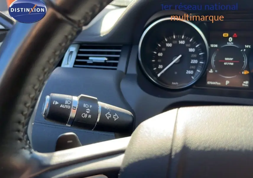 Vue rapprochée du volant et du commodo gauche du tableau de bord d'un Range Rover Evoque blanc de 2017.