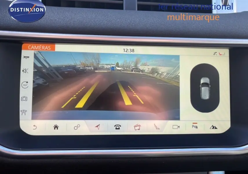 Écran de caméra de recul du Range Rover Evoque blanc 2017, affichant les lignes de guidage jaunes et la vue arrière du parking.