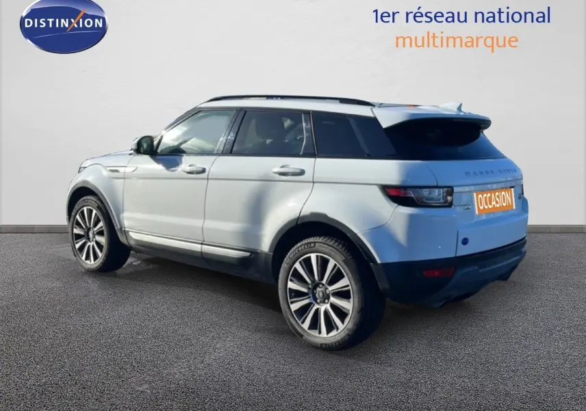 Vue 3/4 arrière gauche d'un Range Rover Evoque blanc 2017 avec jantes alliage bicolores et toit noir contrasté.