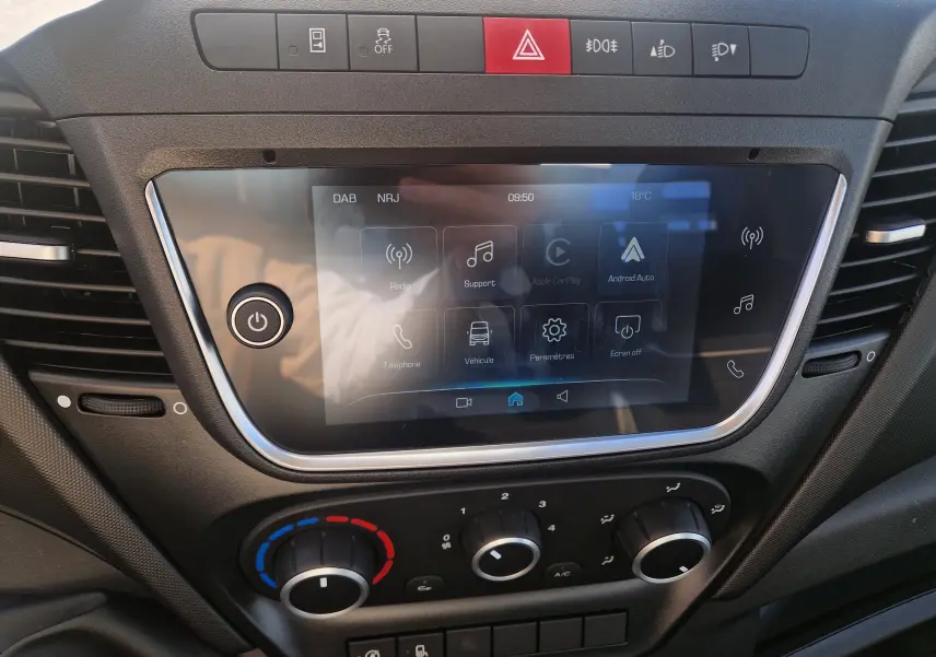 Vue rapprochée de la console centrale du tableau de bord de l'Iveco Daily 2026, avec écran tactile et commandes climatisation.
