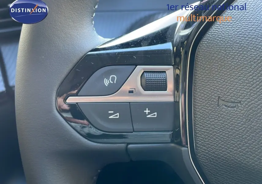 Gros plan sur les commandes de volume et téléphone au volant de la Peugeot 208 Hybrid 110ch finition Allure noire.
