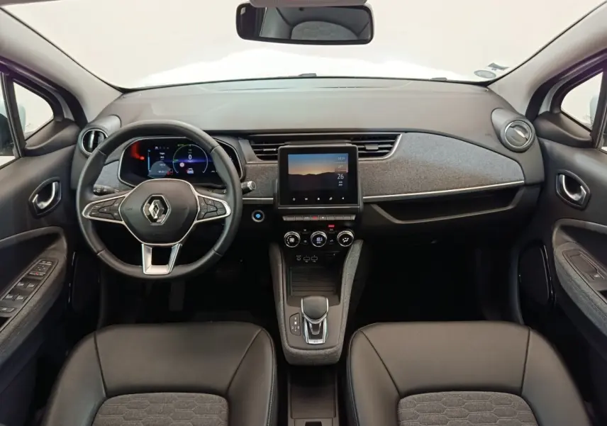 Vue intérieure frontale du tableau de bord de la Renault ZOE Intens R110 avec écran tactile central et volant multifonction.