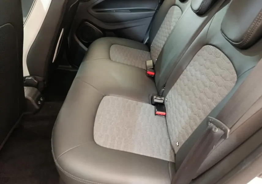 Vue intérieure du siège arrière droit de la Renault ZOE Intens blanc, avec assise bicolore cuir et tissu gris.